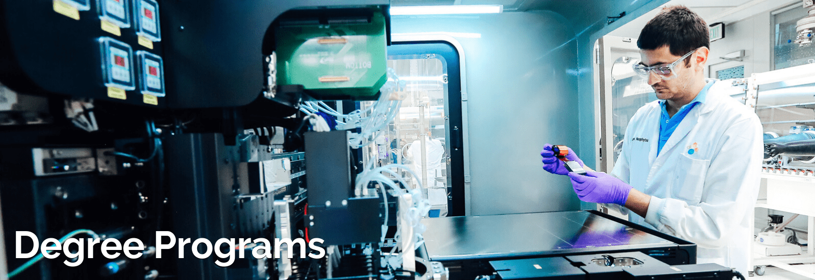 A scientist in a lab coat working with a machine.